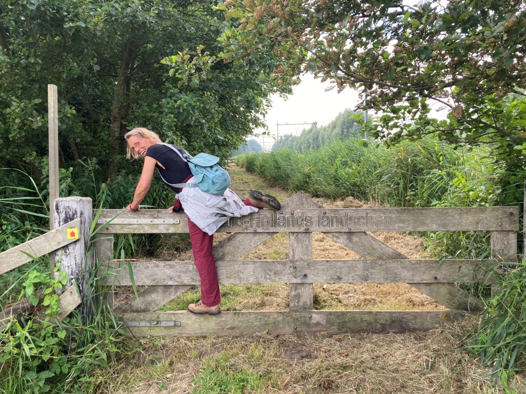 Vrouw-klimt-over-hek